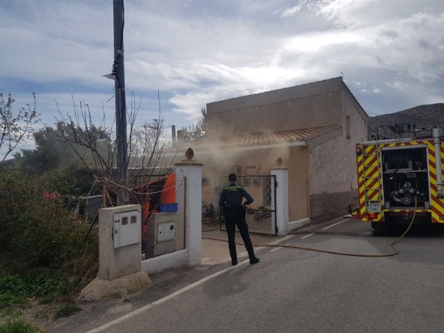 Efectivos de los servicios municipales de emergencias atienden a una mujer mayor en un incendio registrado en una vivienda próxima a la ermita de La Huerta