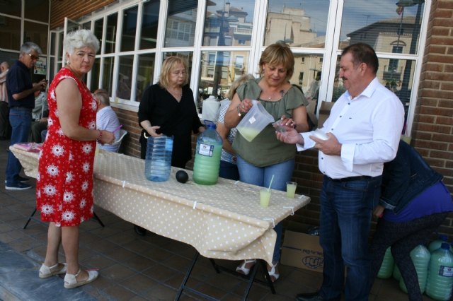 Socios y usuarios del Centro Municipal de Personas Mayores de la plaza Balsa Vieja disfrutan del reparto de agua limón con motivo de las fiestas